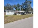 Charming single-story home with a carport, red doors, and lush trees at 723 Jeffcoat St, Apopka, FL 32703