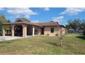 Single story home with a covered carport and small tree in a well-maintained yard at 7411 Golden Glenn Ct, Orlando, FL 32807