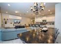 Open-concept living room with modern kitchen, sleek countertops, and a decorative chandelier at 8948 Adriatico Ln, Kissimmee, FL 34747