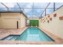 Private in-ground pool inside screened lanai with brick pavers and decorative wall art at 8948 Adriatico Ln, Kissimmee, FL 34747