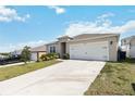 Inviting single-story home featuring a long driveway, well-maintained lawn, and a convenient two-car garage at 9537 Black Walnut Dr, Clermont, FL 34715