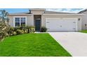 Inviting single-story home featuring a well-maintained lawn and a convenient two-car garage at 9537 Black Walnut Dr, Clermont, FL 34715