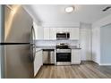 Modern kitchen featuring stainless steel appliances, granite countertops, and sleek white cabinetry at 9913 Peddlers Way, Orlando, FL 32817