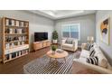 Bright living room with a striped rug, bookshelf, and a comfortable neutral-toned sofa and chair set at 1038 Commuter Dr, Deltona, FL 32738