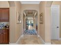 Elegant hallway with arched doorways and tile flooring, leading to various rooms in the home at 1112 Heron Point Way, Deland, FL 32724