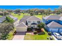 Aerial view of a two-story home with green lawn, landscaping, and two-car garage in a neighborhood with mature trees at 137 Kays Landing Dr, Sanford, FL 32771