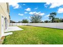 Spacious backyard features a well-maintained lawn and a white fence, perfect for outdoor activities at 137 Kays Landing Dr, Sanford, FL 32771