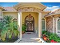 Elegant front entrance with stone columns, arched doorway, and a chandelier at 1502 Hempel Ave, Windermere, FL 34786