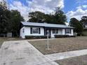 Home exterior with long driveway, green shrubs, and a well-kept lawn at 15081 Sw 35Th Cir, Ocala, FL 34473