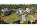 An aerial view of a well-manicured property with a circular driveway and lush landscaping at 17102 Medici Way, Bella Collina, FL 34756