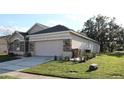 View of the home's side exterior showing the driveway and manicured lawn at 1746 Golfview Drive, Kissimmee, FL 34746