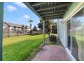 View of the backyard with lawn, fencing, and a glimpse of the apartment complex at 1897 Caralee Blvd # 2, Orlando, FL 32822