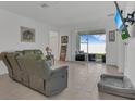 Well-lit living room boasting comfortable seating, tile floors, and sliding glass doors to the patio at 1934 Pond Pine Ct, Haines City, FL 33844