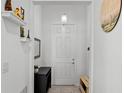 Bright foyer with a white door, tiled floor, and decor on the walls and shelving at 1982 Cricket Cradle Dr, Kissimmee, FL 34746