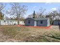 Home exterior featuring gray siding and a large yard with space for recreation at 204 Brooks Rd, Frostproof, FL 33843