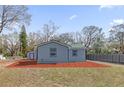 Charming home exterior featuring gray siding, a matching shed, and spacious backyard at 204 Brooks Rd, Frostproof, FL 33843