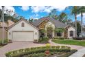 Charming front exterior features lush landscaping, stone accents, and a two-car garage, perfect for curb appeal at 210 Laurel Park Ct, Winter Park, FL 32792