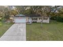 A nice aerial view of the property, with a long driveway and an attached garage at 212 Glenn St, Leesburg, FL 34748