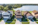 Aerial view of a two-story home with solar panels and a backdrop of a serene lake at 259 Southbridge Cir, Kissimmee, FL 34744