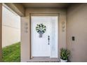 Charming front entrance with a decorated white door, stylish wreath, and attractive plants at 259 Southbridge Cir, Kissimmee, FL 34744