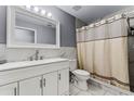 Bathroom featuring marble surround, white vanity, and shower with curtain at 2957 Birmingham Blvd, Orlando, FL 32829