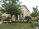 Exterior of home with a well-manicured lawn, lush trees, and beautiful landscaping at 318 Habitat Way, Sanford, FL 32773