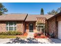 Close-up of the home's entrance with brick accents, a walkway, and updated landscaping at 4124 Winderlakes Dr, Orlando, FL 32835