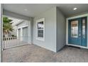 Inviting front porch featuring brick flooring, a teal front door, and a charming view of the surrounding landscape at 4789 Terrace Bluff St, Winter Garden, FL 34787