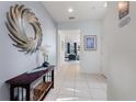 Bright entryway with tile flooring, decorative mirror, and console table, offering a welcoming entrance at 5234 Wildwood Way, Davenport, FL 33837