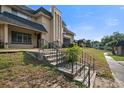 Exterior shot of a two story building with wrought iron railings, stairs and grass area at 5415 Fairwood Way # 303, Orlando, FL 32808