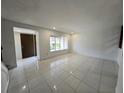 Open living room area with tile flooring and natural light from the front windows at 5415 Fairwood Way # 303, Orlando, FL 32808