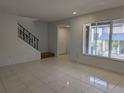 Open living area with tile flooring, staircase, and a bright window at 5415 Fairwood Way # 303, Orlando, FL 32808
