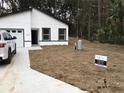 New construction home featuring black trimmed windows and garage with a well manicured lawn at 6937 Se 23 Ave, Ocala, FL 34480