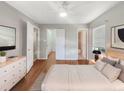 Bright bedroom with wood floors, a window, a ceiling fan, and multiple closets at 700 E Airport Blvd # C7, Sanford, FL 32773