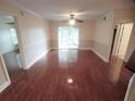 Spacious living room with wood floors, fan, and a sliding glass door providing natural light at 713 Crest Pines Dr # 227, Orlando, FL 32828