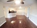 Bright living room featuring hardwood floors, ceiling fan, and an open layout into the kitchen at 713 Crest Pines Dr # 227, Orlando, FL 32828