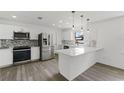 Modern kitchen featuring stainless steel appliances, a sleek backsplash, and a breakfast bar with pendant lighting at 7331 Blue Jacket W Pl, Winter Park, FL 32792