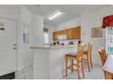 Bright kitchen featuring a breakfast bar with seating, neutral countertops, and tiled flooring at 8452 Crystal Cove Loop, Kissimmee, FL 34747