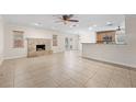 Open living room featuring a stone fireplace, tile floors, and view of the kitchen at 851 Benchwood Dr, Winter Springs, FL 32708