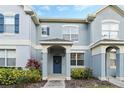 Close-up of the home's entrance featuring a blue door and well maintained landscaping at 8933 Newmarket Dr, Windermere, FL 34786