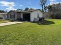 View of the home's exterior showcasing the attached garage and landscaped yard at 1024 W Embassy Dr, Deltona, FL 32725