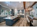 Modern kitchen boasts a large island with seating, stainless steel appliances, and stylish pendant lighting at 105 Pine Street, Windermere, FL 34786