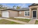 Close up of a charming one-story home with a two-car garage and manicured lawn at 112 Lake Butler Ave, Haines City, FL 33844