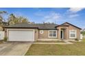 Charming one-story home with a two-car garage, neutral paint and manicured landscaping at 112 Lake Butler Ave, Haines City, FL 33844