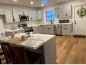 Modern kitchen with gray cabinets, stainless steel appliances, and an island with seating at 2013 Bates Ave, Eustis, FL 32726