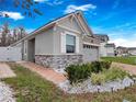 Well-maintained home with a stone facade, a brick walkway, and manicured landscaping at 2479 Empress Dr, Kissimmee, FL 34741