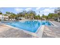 Community pool featuring crystal clear water and plentiful lounge chairs surrounded by well-maintained landscaping at 2623 Buena View Rd, Kissimmee, FL 34746