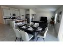 Well-staged dining area features an oval dining table, chairs, and flows into the living space at 313 Estates Ct, Haines City, FL 33844