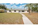 Charming one-story home featuring a well-maintained lawn, walkway, and neutral-toned paint scheme with a palm tree in the front yard at 345 Overstreet Ave, Longwood, FL 32750