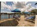 Wooden deck with lounge chairs and tables overlooking the water at 4008 San Gallo Dr # 102, Kissimmee, FL 34741